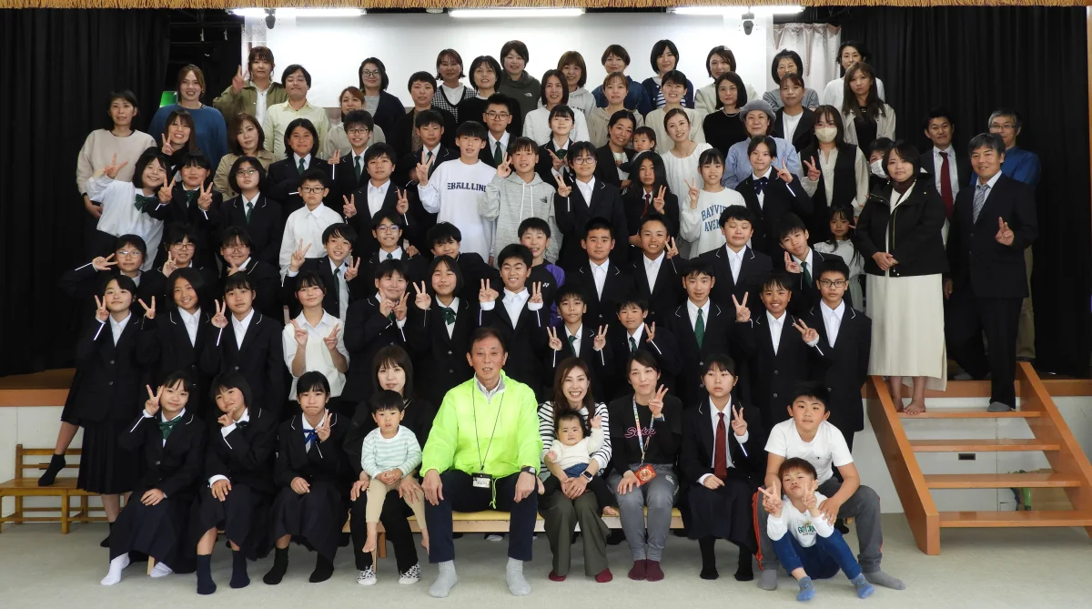 ホールの階段に、園児と大人が何列にも並んで写った集合写真