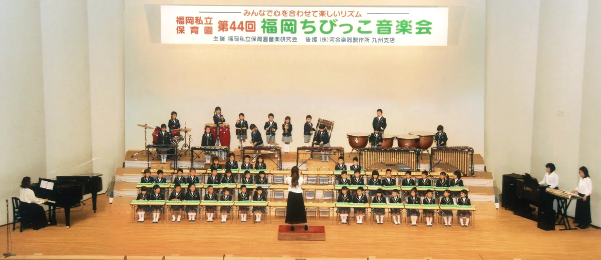 ホールの舞台に園児が並んで演奏する、ちびっこ音楽会の様子